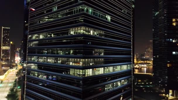 Außen malerische moderne Wolkenkratzer mit leuchtenden Bürofenstern am Abend. Schuss. das Konzept des Nachtlebens in Großstädten. Blick von oben auf Büros eines Hochhauses in der Nacht — Stockvideo