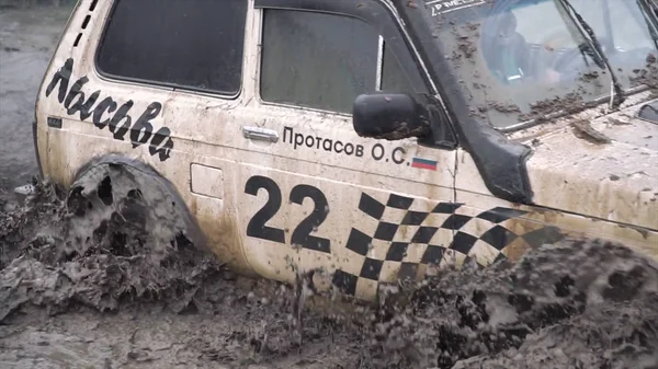 Moscú, Rusia - septiembre de 2018: Paseos fuera de carretera en charco profundo fangoso. Clip. Los coches participan en carreras anuales off-road. Primer plano de inmersión de SUV en charco — Foto de Stock