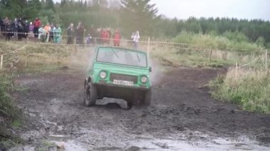 Off-Road çamurlu su birikintisi rekabet jeep sırasında büyük sıçrama ile toprak yol üzerinde sürme. Küçük. Kavram extreme sürüş. SUV hız çamurlu su birikintisi girer