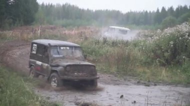 SUV Yarışması'nda sprey üstündeki toprak yolda gidiyor. Küçük. Araba almak bölüm içinde kırsal yıllık off-road yarışlarında arka planda hayranları ile bulutlu havalarda