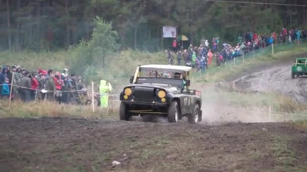 Moscou, Rússia - setembro de 2018: Carros participam de corridas off-road anuais. Clipe. Close-up de SUVs passando na pista suja no fundo dos fãs — Vídeo de Stock