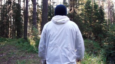 Genç adam kamp gezisinde. Görüntüleri. Özgürlük ve doğa kavramı. Adam ormanda yol boyunca güneşli sonbahar gününde yürüyüş arkadan görünümü