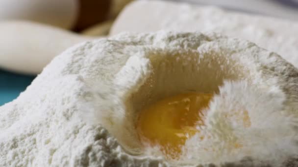 Yolk cade nella farina al rallentatore, da vicino. Scena. Cadendo uova nel brodo di farina. Cibo per filmati. Uovo che cade nella farina, al rallentatore. Food Blog, Prodotti della farina. Prodotti da forno. Preparazione di — Video Stock