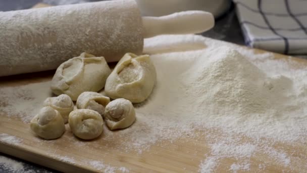 Tavola di legno con mattarello, farina, gnocchi e torte. Preparazione di pasta. Scena. Ingredienti Per l'impasto e un mattarello . — Video Stock