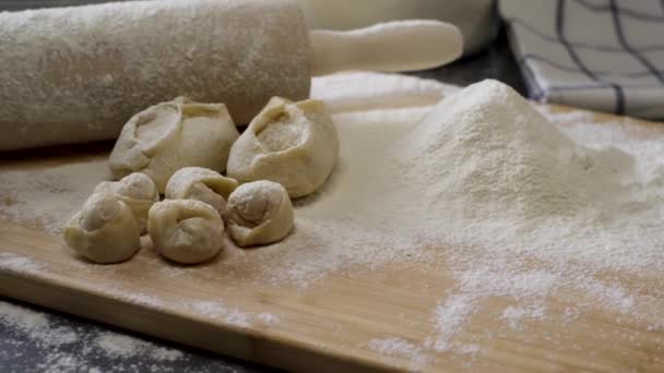 Placa de madeira com rolo de pino, farinha, bolinhos e bolos. Preparação de massa. Cena. Ingredientes Para a massa e um rolo . — Vídeo de Stock