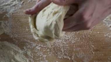 Masada unu hamur yoğurma Baker. Sahne. Adam şef hamur kneads. Eller mutfak tabloda hamur yoğurmak kadar yakın