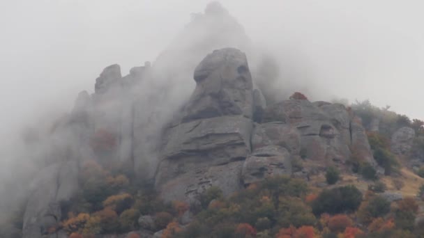 雲の上の山の範囲を移動します。ショット。険しい、ロッキーの山のピークおよび厚い霧と雲に包まれている風景. — ストック動画