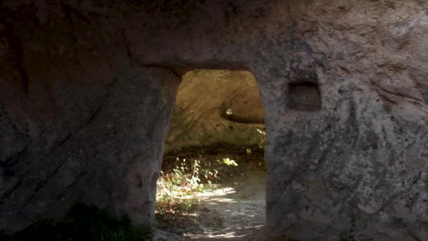 Antica grotta con porta. Gli hanno sparato. Interno con focolare di antica stanza in grotta. Dalle vecchie grotte, muri di pietra. Dalle vecchie grotte, muri di pietra . — Video Stock