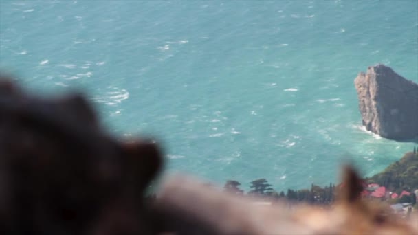 Panoramautsikt över havet med enorma rock och liten stad bakgrund. Skott. Utsikt över havet bukten och staden i bukten från stenar, vackra seascape på en solig sommardag, blå havet och blå himmel. — Stockvideo