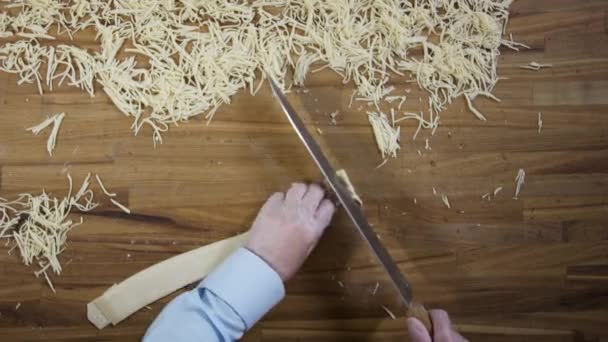 Top view hands of chef making egg homemade noodles. Scene. Baker hands cutting the dough. Top view on male hands with knife cutting dough - making pasta or noodles — Stock Video