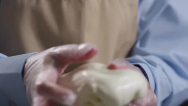 Baker hands a tészta készül. Jelenet. Férfi kézi dagasztás tészta és víz hozzáadásával, lassan közelről. Baker kéz, zuhogó víz tálba Liszt a dagasztás tészta, pékség bolt — Stock videók
