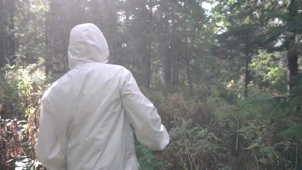 Hombre con machete abriéndose camino a través del matorral. Filmación. Vista de cerca del hombre desde la espalda sosteniendo machete en su mano — Vídeos de Stock