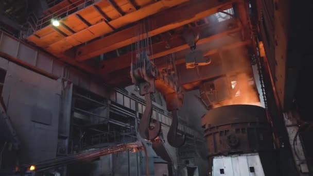 View of smelting of metal with ladle inside foundry. Footage. Interior of dirty metallurgical plant in dark. Concept of heavy industry — Stock Video