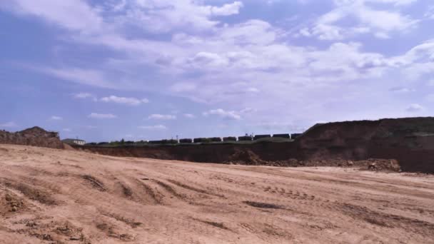 Vy över stenbrottet. Scen. Landskap byggarbetsplats med stenbrottet och sand på bakgrund av passerande godståg — Stockvideo