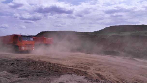 Dump truck on dirt road in large dust cloud. Scene. Fog of dust on quarry road after big passing truck. Concept of heavy transport — Stock Video