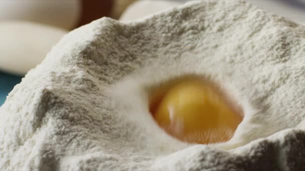 Close-up of egg in flour. Scene. Concept of cooking. Preparation of homemade cakes from white flour — Stock Video