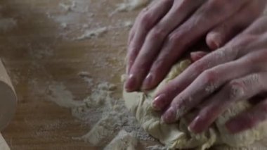 Tatlı hamur elle yoğrulur. Sahne. Cook hamur un serpilir masada kneads. Ev yemekleri kavramı