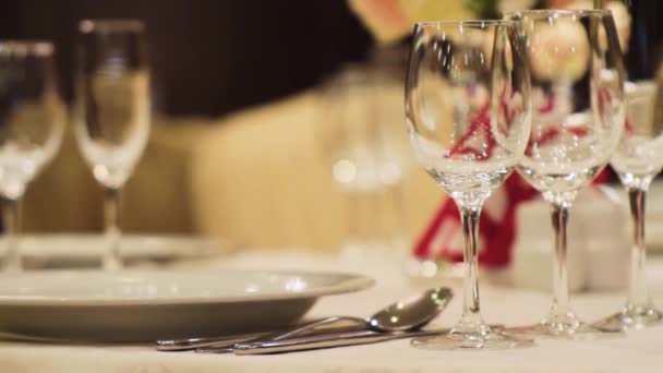 Detail sklenice na víno. Scénu. Prázdné víno brýle v elegantní restauraci na pozadí nádherné kytice — Stock video