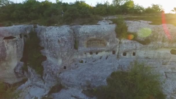 Ruins of ancient town of cave-quarters inside sheer rock deserted place. Shot. Aerial view on ancient settlement in rocks and caves. — Stock Video