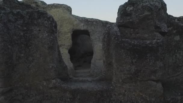 Ruins of ancient town of cave-quarters inside sheer rock deserted place. Shot. Aerial view on ancient settlement in rocks and caves. — Stock Video