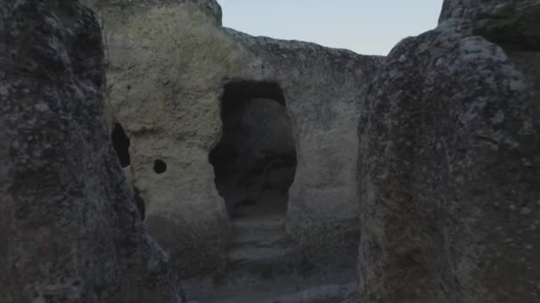 Ruines de l'ancienne ville de cavernes à l'intérieur de rocher pur endroit désert. Fusillade. Vue aérienne sur l'ancienne colonie dans les rochers et les grottes . — Video