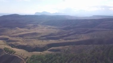 Havadan görünümü Dağları zirve, doğal yolu, dağ ile ağaçlar ve bitkiler, bitki örtüsü, gökyüzü bulutlar arka plan ile. Vurdu. Çim, büyük yeşil alanlar ve güzel manzara ile dağ silsilesi