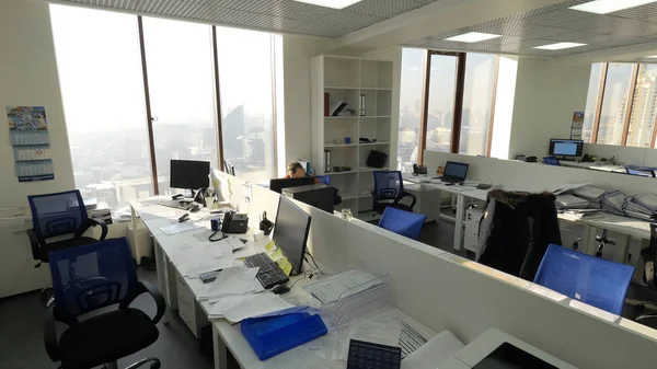 Görünüm iş ofis iş yerinde tek başına oturan bir çalışan ile. Büyük açık plan office çalışkan ile görünümünü. Ofis işleri kavramı — Stok fotoğraf