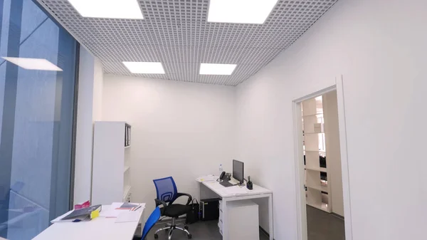 Blick ins kleine Büro. arbeitsfreie Zeit im Amt. moderner, kompakter Büroraum mit mehreren Arbeitsplätzen und hellem Kunstlicht. Konzept des Büroinnenraums — Stockfoto