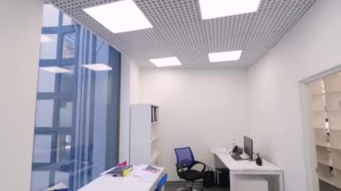 Küçük ofis görünümü. Çalışma dışı zaman ofiste. Modern kompakt ofis oda çeşitli iş istasyonları ve parlak yapay ışık. Ofis iç kavramı