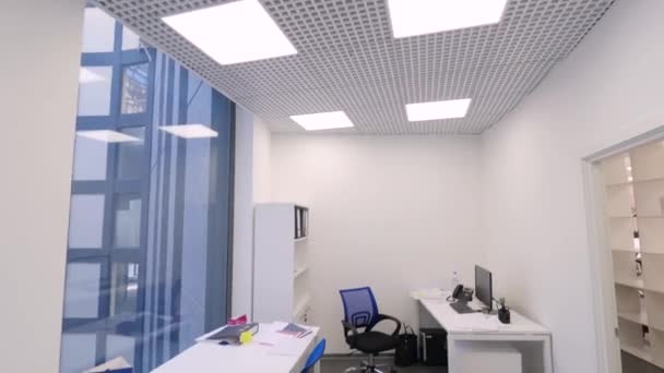 Blick ins kleine Büro. arbeitsfreie Zeit im Amt. moderner, kompakter Büroraum mit mehreren Arbeitsplätzen und hellem Kunstlicht. Konzept des Büroinnenraums — Stockvideo