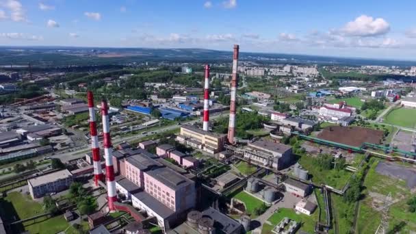 Draufsicht auf Schornsteine von Fabrik- und Stadtgebäuden. Filmmaterial. Produktionsgebäude an der Skyline von Himmel und grünem Wald in der Stadt — Stockvideo