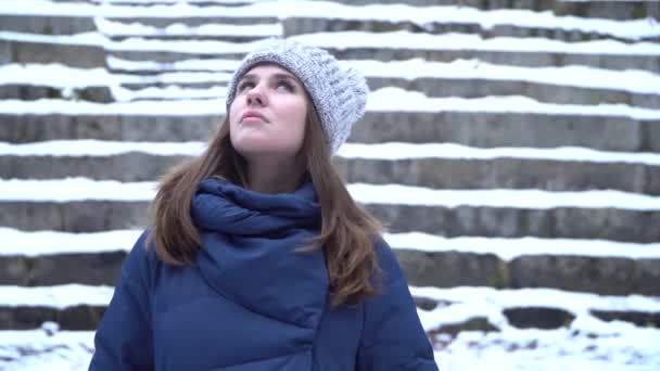 Ritratto ravvicinato di bella giovane donna caucasica sorridente in giacca invernale, cappello e sciarpa. Bruna ragazza nevoso legno ritratto . — Video Stock