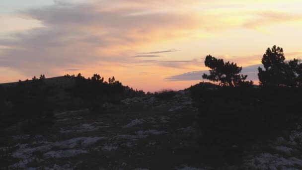 Blick von oben auf felsigen Gipfel auf dem Hintergrund des Sonnenuntergangs Farben mit Wolken. Schuss. bunte malerische Landschaft des Sonnenuntergangs Himmel mit Wolken — Stockvideo