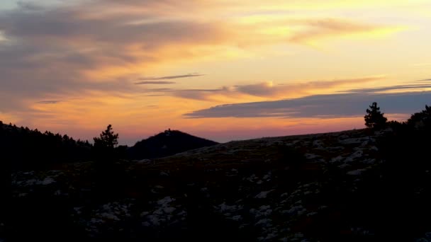 Silueta negra de colina al atardecer con nubes. Le dispararon. Vista superior de la pintoresca puesta de sol. Cielo está pintado en colores brillantes en terreno montañoso — Vídeo de stock