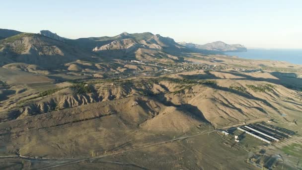 Vue sur les chaînes de montagnes désertiques et la ville. Fusillade. Panorama de maigres collines verdoyantes et horizon de montagne avec littoral 