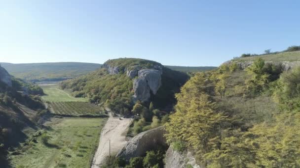 Blick von oben auf das Erholungszentrum im Tal der Felsenberge. Schuss. Panorama des Tals der Schlucht Felsvorsprünge mit Gärten von Bäumen und Häusern — Stockvideo