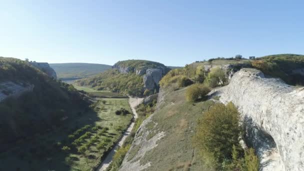 Blick von oben auf die Plantage im Bergtal. Schuss. Panorama vom Steinrücken der Felswände bis ins grüne Tal bei sonnigem Wetter — Stockvideo