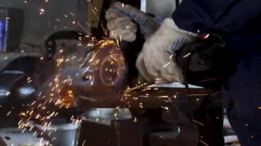 Erkek el nargile parçaları açısı öğütücü ile keser. Bir çelik inşaat alanında kıvılcım sıçraması ile kesme. Metal açılı taşlama kesim sırasında kıvılcım