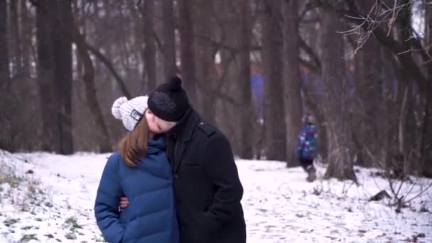 Casal jovem abraçando e beijando no Parque no inverno. Retrato de um belo casal vestido com roupas de inverno no dia frio de inverno. Jovem casal desfrutando de um momento romântico — Vídeo de Stock