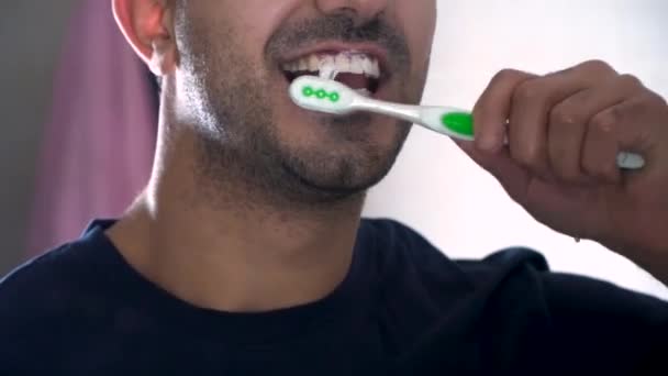 Reflejo de un joven lavándose los dientes en el baño. Imagen de cerca de un hombre cepillándose los dientes en el apartamento. cuidado de la salud, higiene dental, personas y concepto de belleza — Vídeos de Stock