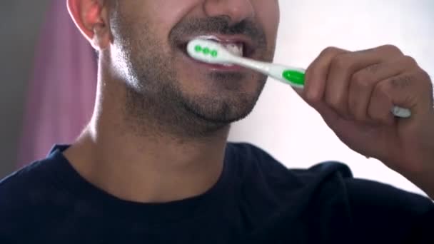 浴室で彼の歯を磨く若い男の反射。アパートで歯を磨く男のクローズ アップ画像。医療、歯科衛生、人々、美しさの概念 — ストック動画