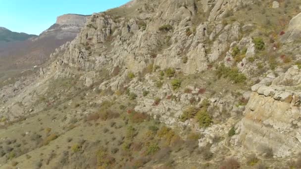 Blick von oben auf ein Tal mit Bergen im Sommer. Schuss. wunderbare Luftaufnahme von Hügeln, Felsen und blauem Himmel — Stockvideo