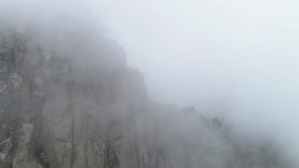 안개에 산의 사면입니다. 총. 짙은 회색 안개 봉투 전체 공간. 차가운가 안개에 폭락 하는 바위의 상위 뷰 — 비디오