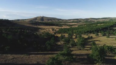 Üstten görünüm Hills yeşil ağaçlar ve alan. Vurdu. Tepeler ve orman parçaları ile düz Panoraması. Üstünde tepe-in tepe açık gökyüzü ufukta beyaz Gözlemevi