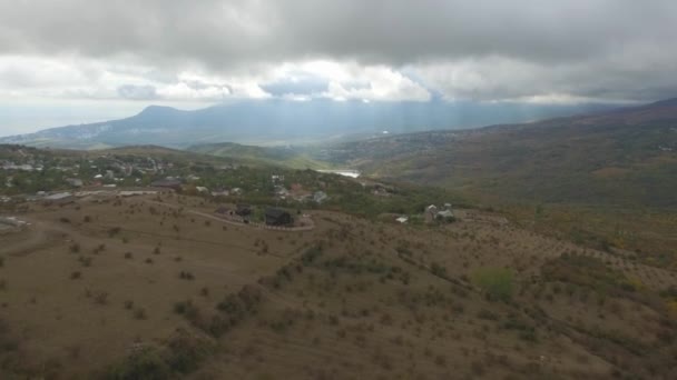 Flygfoto över en by i den vackra moln och solljus framför bergen. Skott. Det vackra bergiga landskapet i Japan. — Stockvideo