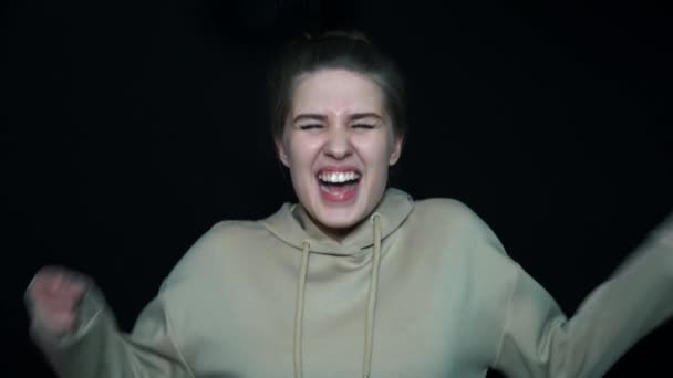 Screaming girl in a black background. Portret of very angry woman. — Stock Video