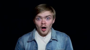 Siyah arka plan üzerine izole kamera, bakıp ağzı açık tutarak şaşırmış Genç, sakallı adam. Duygusal, çekici açık ağız adam şok, sürpriz