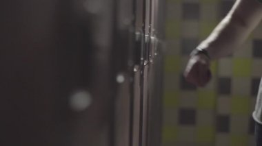 El bileği soyunma odası spor salonunda elektrik anahtar ile soyunma açılış mans. Çerçeve. Spor salonu soyunma odasında Dolap Kapı açma el kadar kapatın.