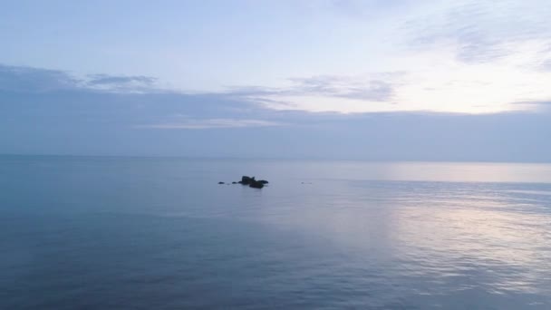 Zeegezicht met kleine rotsen uit water en prachtige blauwe bewolkte hemel. Schot. Romantische sfeer in vreedzame zonsondergang op zee. — Stockvideo
