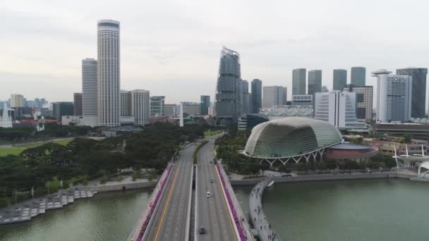 Aérea para Singapur con muchos coches en el puente sobre el lago y los edificios de la ciudad de fondo. Le dispararon. Ciudad de Singapur skyline con puente y edificios modernos . — Vídeos de Stock